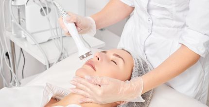 Beautician makes ultrasound skin tightening for rejuvenation woman face using phonophoresis